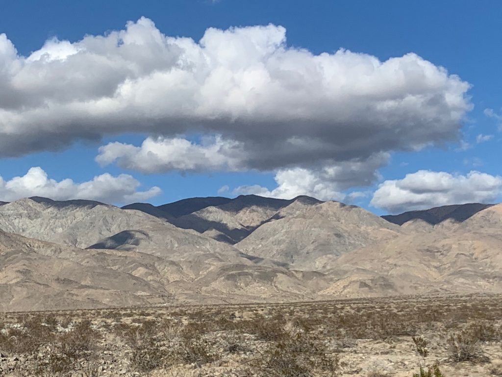 clouds hover over desert mountains